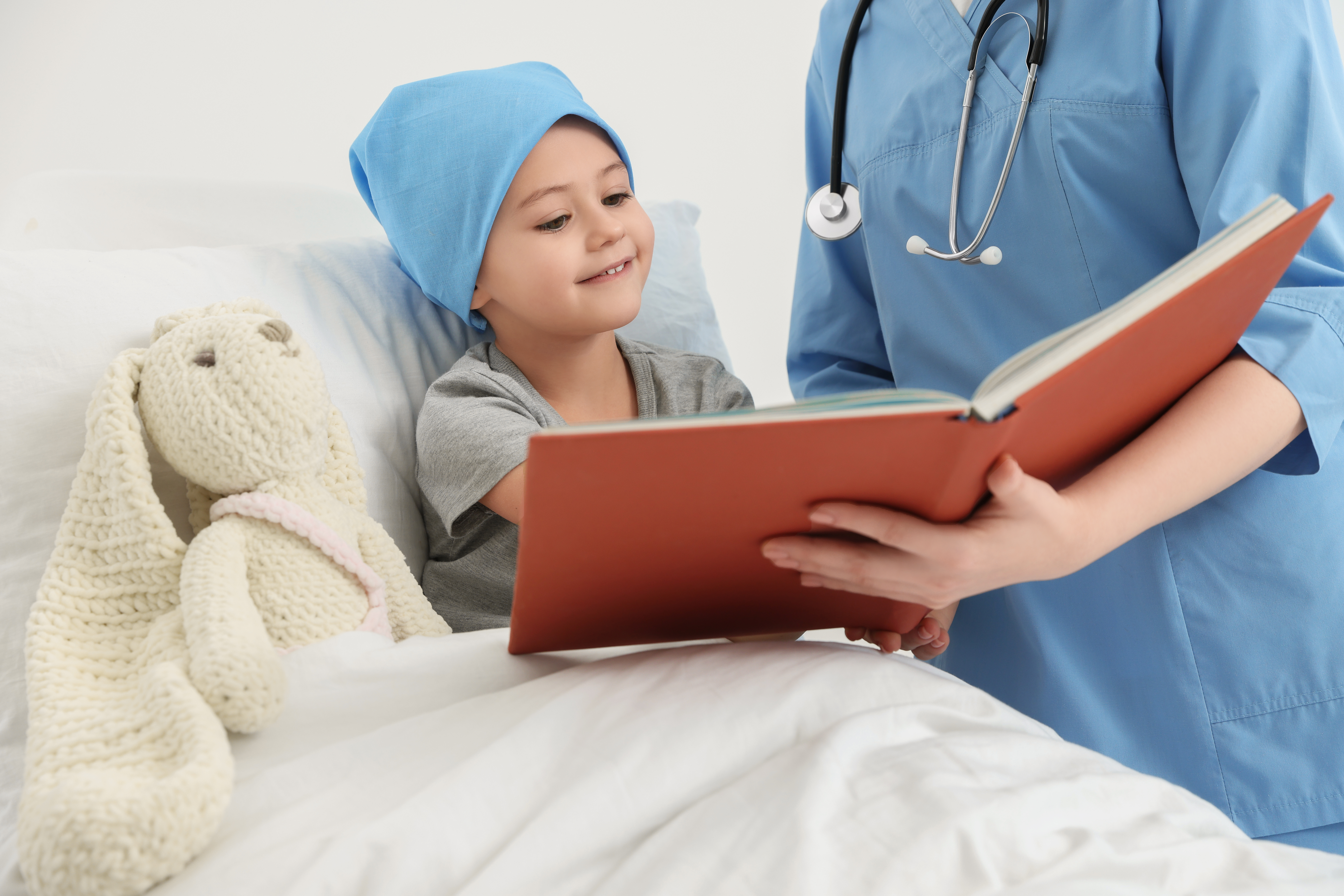 Childhood cancer. Doctor and patient reading book in hospital